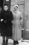 Two women wearing overcoats on a snow covered street in the Kielce ghetto.