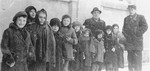 Group portrait of children from a Kielce ghetto orphanage standing on the street.