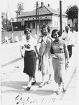 Three young Jewish women walk along a street in Debica, Poland.