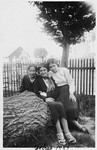 Three young women pose outside in a yard in Debica, Poland.