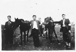 Jewish youth wearing armbands pose with horses in Bedzin, Poland.