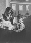 Friederike Oppenheimer cradles her newborn son, Rudi, while his older brother Paul looks on.