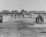 Germans incarcerated in the Recklinghausen internment camp fill puddles in the camp yard.