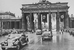 Adolf Hitler rides in a motorcade through the Brandenburg Gate to the opening ceremonies of the 11th Olympiad in Berlin.