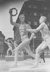Statues of idealized male and female athletes on the street in celebration of the Olympic Games.