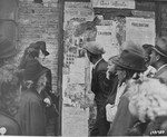 Some of the Belgian inhabitants of Mons look at the photos of collaborators posted on a public bulletin board.