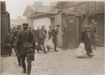 Jewish laborers are forced by SS troops to evacuate a Warsaw ghetto factory during the uprising.