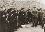 Jews captured by the SS during the Warsaw ghetto uprising are interrogated beside the ghetto wall before being sent to the Umschlagplatz.