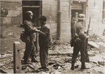 An SS soldier searches a captured Jewish resistance fighter during the suppression of the Warsaw ghetto uprising.