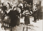 Jews captured by SS and SD troops during the suppression of the Warsaw ghetto uprising are forced to leave their shelter and march to the Umschlagplatz for deportation.
