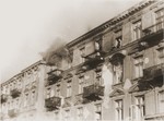 A man perched on the ledge outside of a fourth story window prepares to commit suicide by jumping rather than be captured by the SS on the fourth day of the suppression of the Warsaw ghetto uprising.