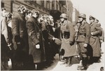An SS Sergeant (Oberscharfuehrer) interrogates religious Jews captured during the suppression of the Warsaw ghetto uprising.