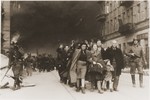 Jews captured during the suppression of the Warsaw ghetto uprising are led away from the burning ghetto by SS guards.