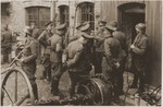 SS and German army officers, accompanied by SD guards, discuss the evacuation of a factory in the Warsaw ghetto during the uprising.