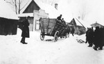 Jews drive a wagon along a snow covered street in the Zawiercie ghetto.
