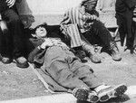 Close-up portrait of a survivor taking a nap in the Dachau concentration camp.