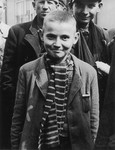 Close-up portrait of a child survivor of the Dachau concentration camp wearing a knit scarf.
