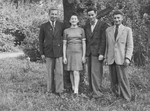 Portrait of four Jewish displaced persons in a garden in Warsaw.