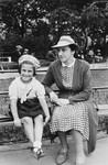A young Jewish child and her aunt sit on a park bench in Bratislava.