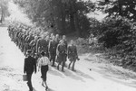 SS officers and enlisted men march to shooting practice.