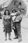 Portrait of a Jewish couple and their daughter standing in front of a home in Thorn (Torun).