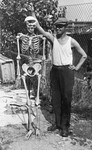 A young man poses with a human skeleton after the liberation of Buchenwald.