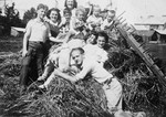 The children of an extended Lithuanian Jewish family poses on top of a haystack.