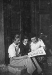Three Jewish youth share a daily Yiddish newspaper.