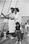A Greek Jewish family stands on board a ship.
