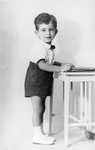 Portrait of three-year-old Tomas Kulka standing next to a table in Olomouc, Czechoslovakia.