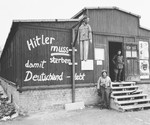 An American soldier poses next to an effigy of Hitler hanging in front of a barracks in the Buchenwald concentration camp.