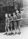 Four young members of Hashomer Hatzair pose standing in a row in the Stuttgart displaced persons' camp.