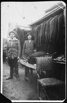Polish-Jewish immigrants pose in an outdoor market with the suits they have sewn.
