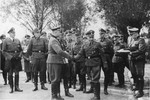 Nazi officers watch Commandant Richard Baer  shakes hands with Karl Bischoff during the dedication of the new SS hospital in Auschwitz.