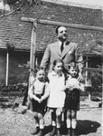 An Austrian-Jewish gentleman poses with his sister's children while visiting them in their home in Zalaegerszeg, Hungary.