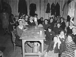 Female survivors gather by a table in a barrack of the Dachau concentration camp.