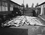 Corpses are laid out in rows prior to burial outside a barracks in the Dachau concentration camp.