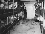 Survivors look out from their bunks inside a barrack in the Dachau concentration camp.