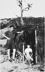 Sergio Minerbi (on right) with his friend Maurizio Pontecorvo stand by a thatched hut at Piastre, Italy during a summer excursion.