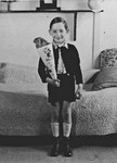 A German-Jewish refugee child poses with a cone filled with treats on his first day of school in the Westerbork internment camp.