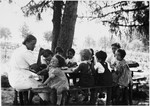 Young children gather around a picnic table in the Chateau des Avenieres children's home in Cruseiles.