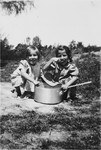Two little girls eat from a large pot in the Chateau des Avenieres children's home in Cruseiles.