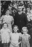 A young Jewish child poses with her rescuers and their foster daughter while in hiding.