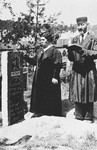 A couple prays at a grave in a Jewish cemetery.