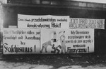 Anti-Nazi posters in German and Polish drawn by freed prisoners hang outside a barrack of the Buchenwald concentration camp.