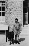 A young German-Jewish boy poses outside his home with his dog in Rimbeck, Germany.