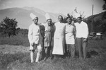 Group portrait of five men wearing chef's hats and aprons in a displaced persons' camp in Switzerland.
