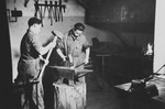 Two young Jewish survivors work in a blacksmith shop in a children's home in Switzerland.