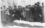 Jewish men saw a large log in the snow in either the Foehrenwald or Windsheim displaced persons' camp.