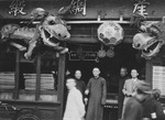 Chinese merchants stand outside their shop in Shanghai.